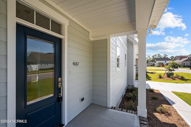 view of exterior entry with covered porch and a residential view