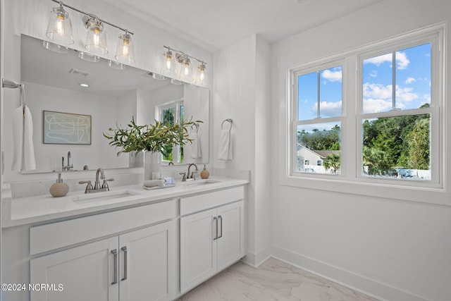 bathroom with a healthy amount of sunlight, baseboards, and a sink