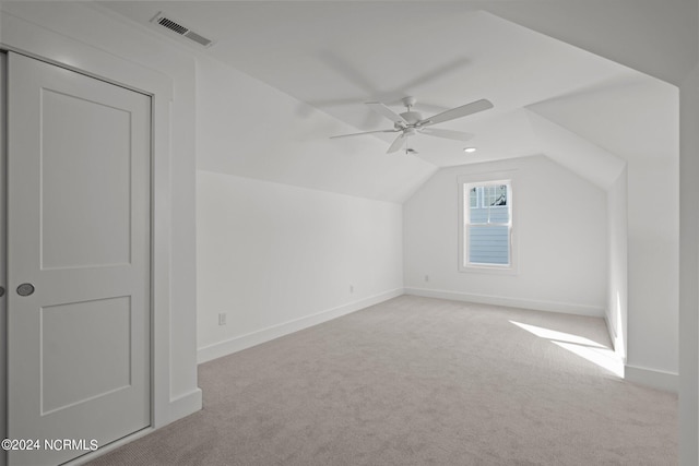 additional living space with carpet, visible vents, a ceiling fan, vaulted ceiling, and baseboards