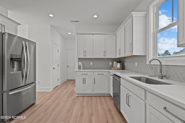 kitchen featuring a sink, visible vents, white cabinetry, light countertops, and appliances with stainless steel finishes