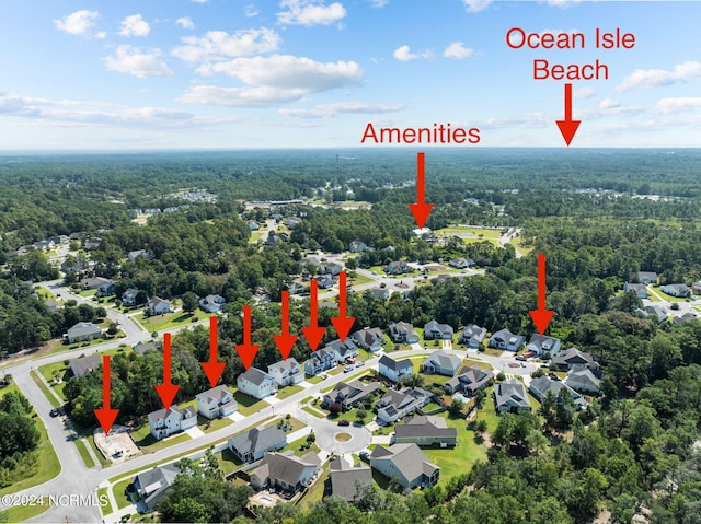 drone / aerial view featuring a residential view and a wooded view