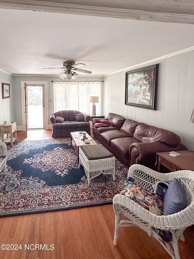 living room with wood-type flooring, ceiling fan, and ornamental molding