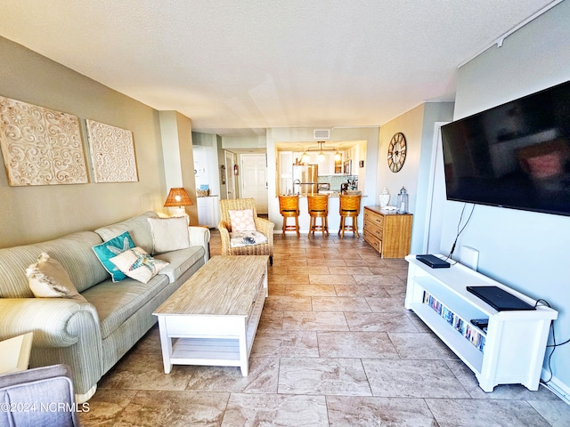 living room with a textured ceiling and light tile floors