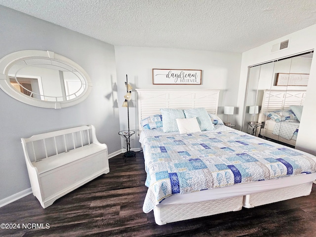 bedroom with a textured ceiling and dark hardwood / wood-style floors