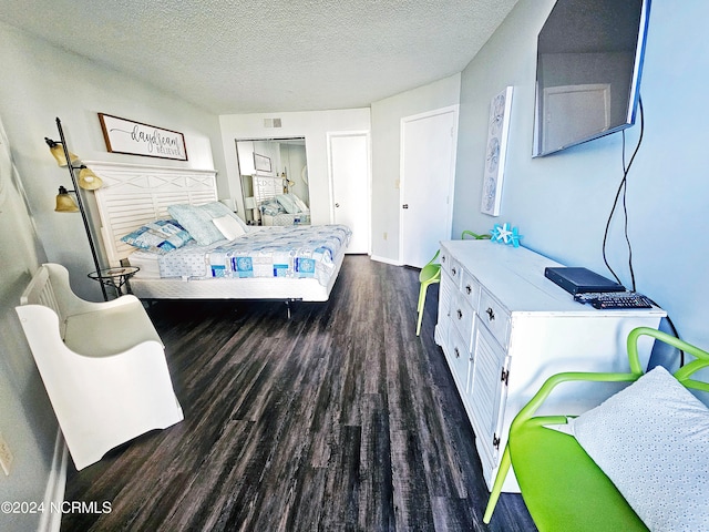 bedroom with a textured ceiling and dark hardwood / wood-style floors