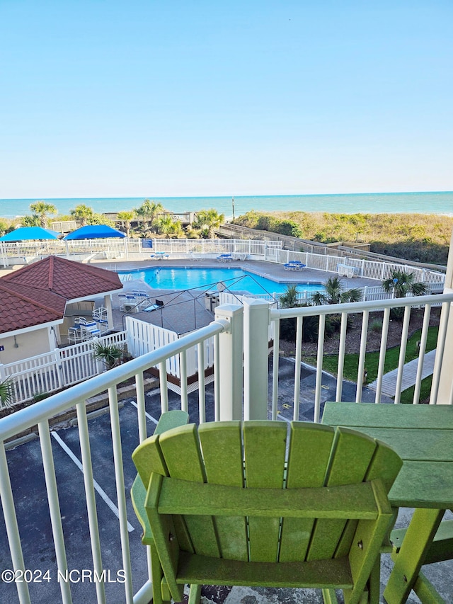 balcony with a water view and a community pool