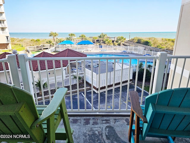 balcony featuring a community pool and a water view