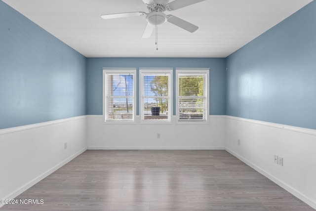 spare room with ceiling fan, baseboards, and wood finished floors