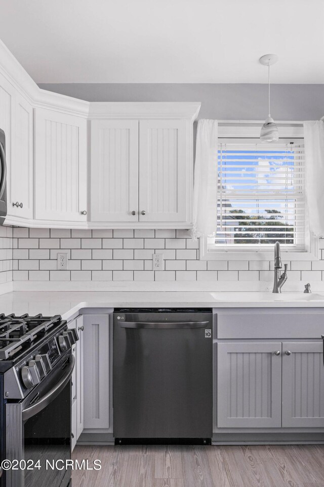 kitchen with dishwasher, pendant lighting, tasteful backsplash, and gray cabinets