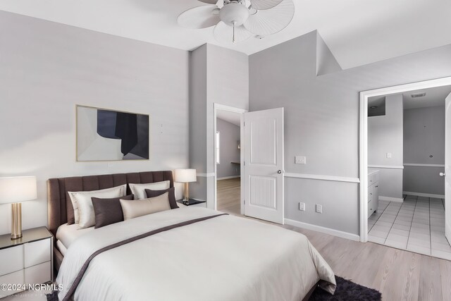 bedroom featuring ensuite bathroom, light hardwood / wood-style flooring, and ceiling fan