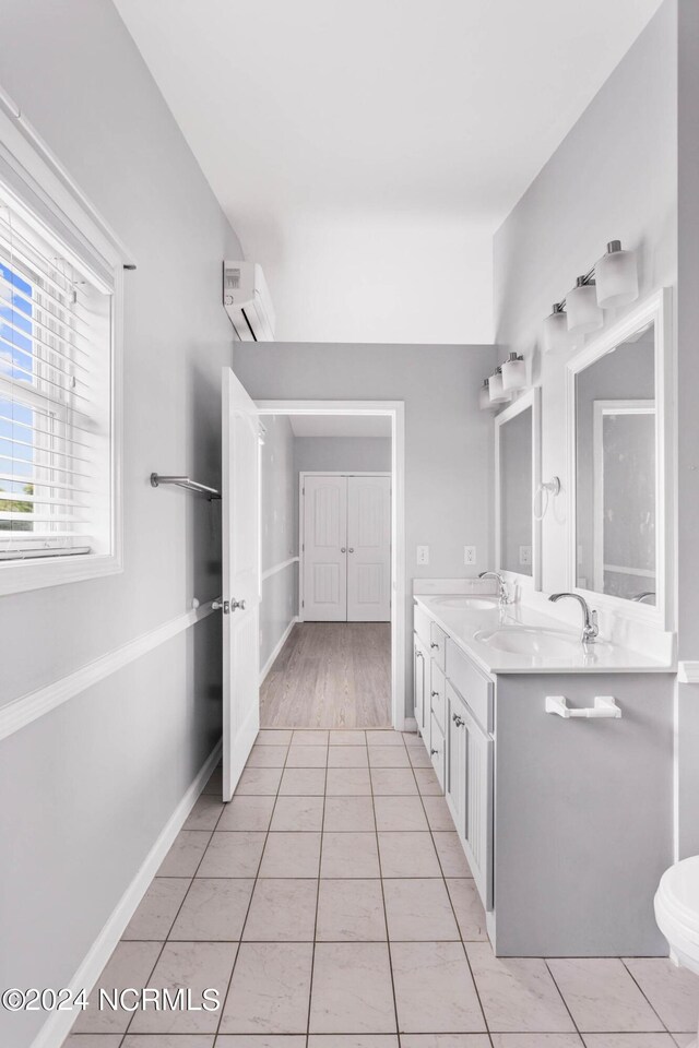 bathroom featuring tile patterned floors, vanity, and a wall mounted AC