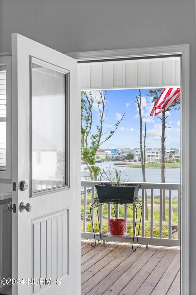 doorway to outside with plenty of natural light, a water view, and hardwood / wood-style flooring