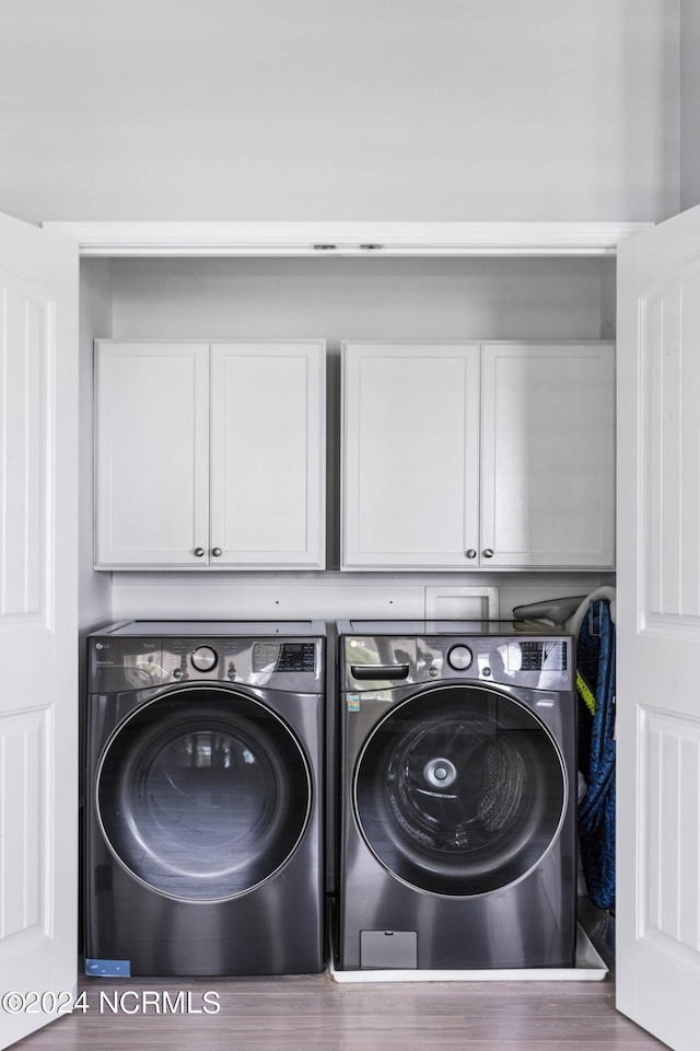 clothes washing area with cabinet space and washer and dryer