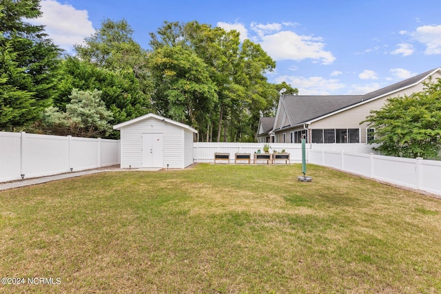 view of yard featuring an outbuilding, a storage unit, and a fenced backyard