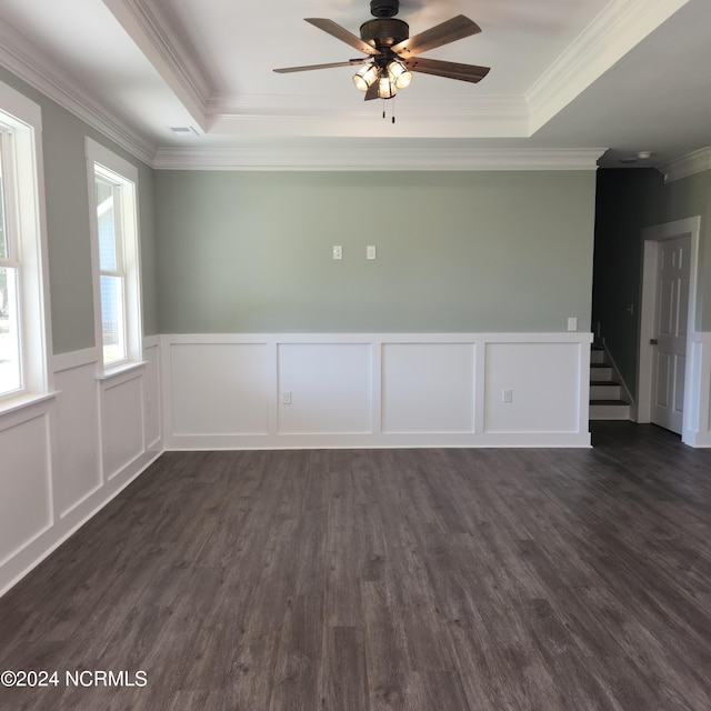 unfurnished room featuring ceiling fan, ornamental molding, a tray ceiling, and dark hardwood / wood-style flooring