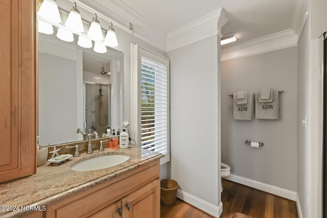 bathroom featuring wood-type flooring, vanity, toilet, and crown molding