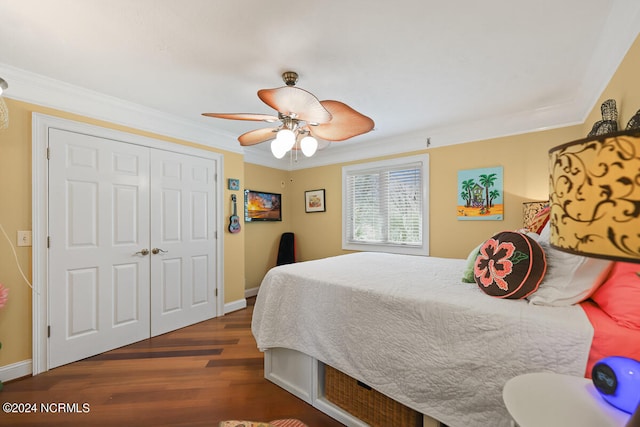 bedroom with dark wood-type flooring, a closet, ceiling fan, and crown molding