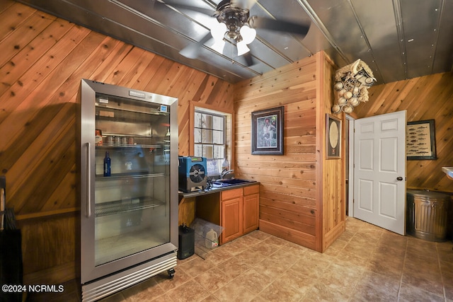 kitchen with light tile floors, high end refrigerator, wood walls, and ceiling fan