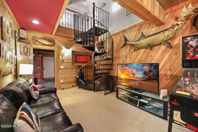 carpeted living room with beamed ceiling and wood walls