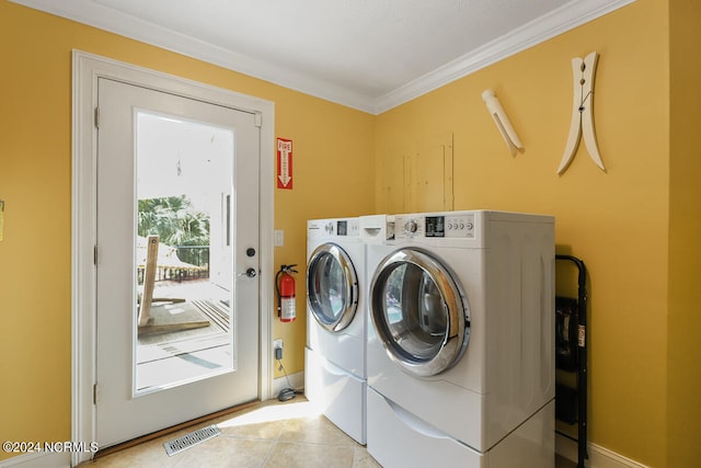 laundry area with washer and clothes dryer, ornamental molding, and light tile flooring