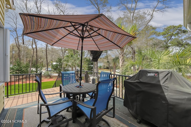 wooden deck with a lawn and a grill