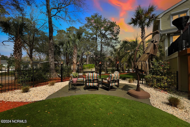 yard at dusk featuring a patio