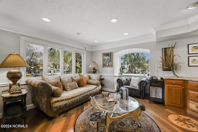 living room with crown molding, a textured ceiling, and hardwood / wood-style floors