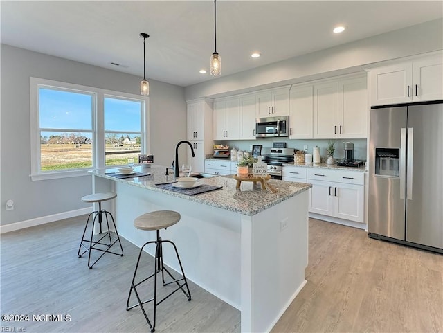 kitchen featuring stainless steel appliances, white cabinetry, and light wood-type flooring