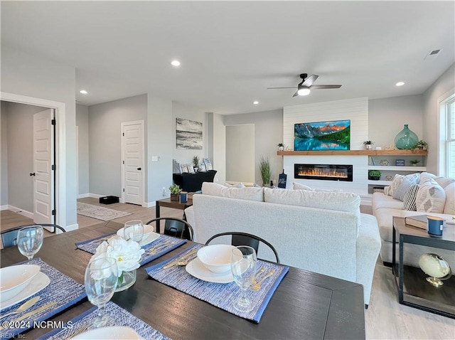 interior space featuring ceiling fan, light wood-type flooring, and a fireplace