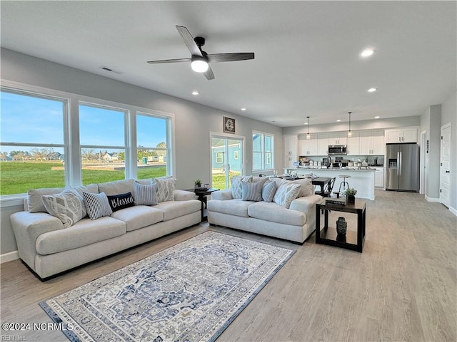 living room featuring ceiling fan and light wood-type flooring