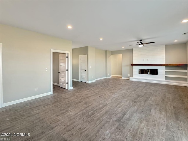 unfurnished living room with ceiling fan, dark hardwood / wood-style floors, and a fireplace