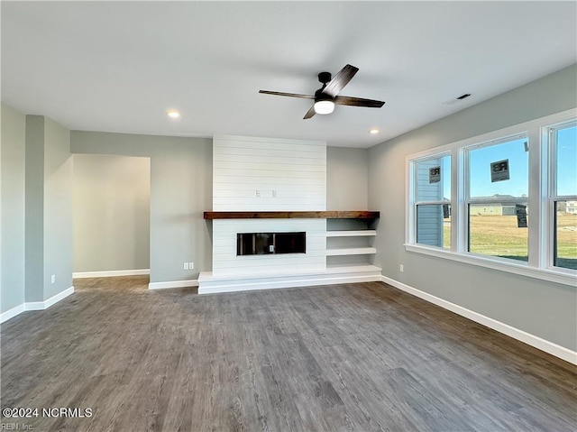 unfurnished living room featuring dark hardwood / wood-style flooring, a fireplace, and ceiling fan