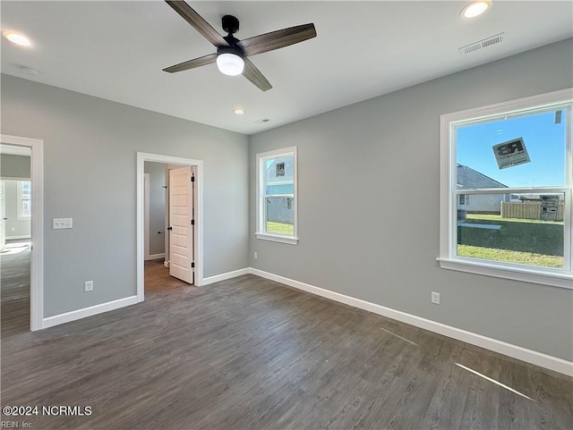 unfurnished bedroom with dark hardwood / wood-style flooring, ceiling fan, and multiple windows