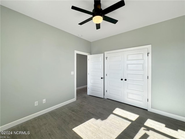 unfurnished bedroom featuring a closet, dark hardwood / wood-style floors, and ceiling fan