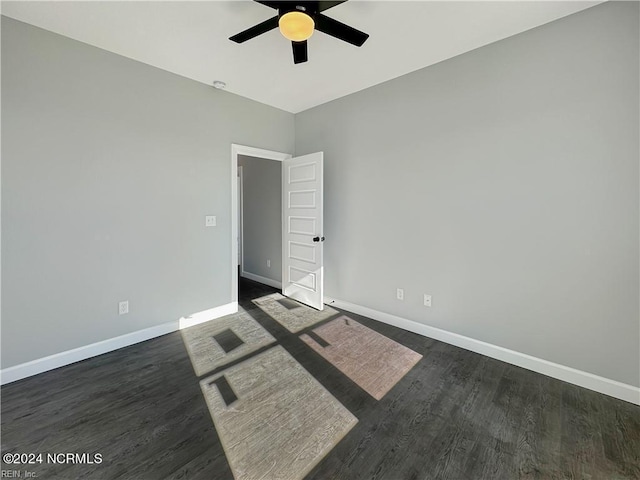 unfurnished room featuring ceiling fan and dark wood-type flooring