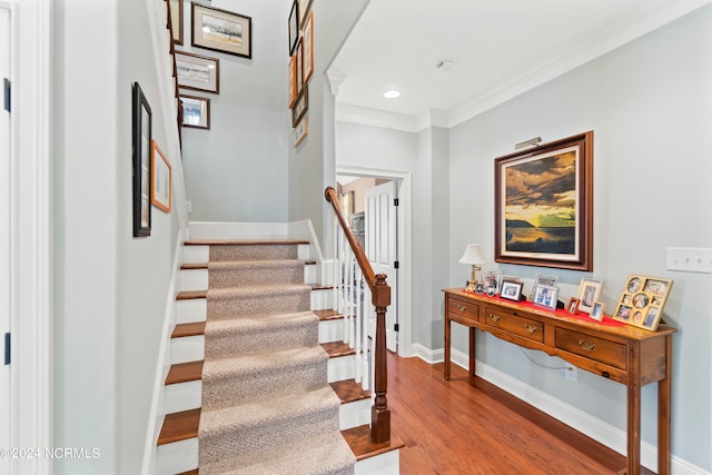 stairway featuring dark hardwood / wood-style floors and ornamental molding