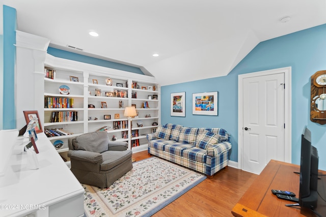 living room featuring vaulted ceiling and light wood-type flooring