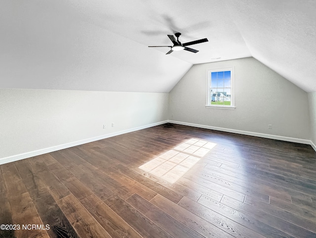 bonus room featuring ceiling fan, dark hardwood / wood-style floors, vaulted ceiling, and a textured ceiling