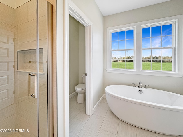 bathroom with a bathing tub, tile floors, and toilet