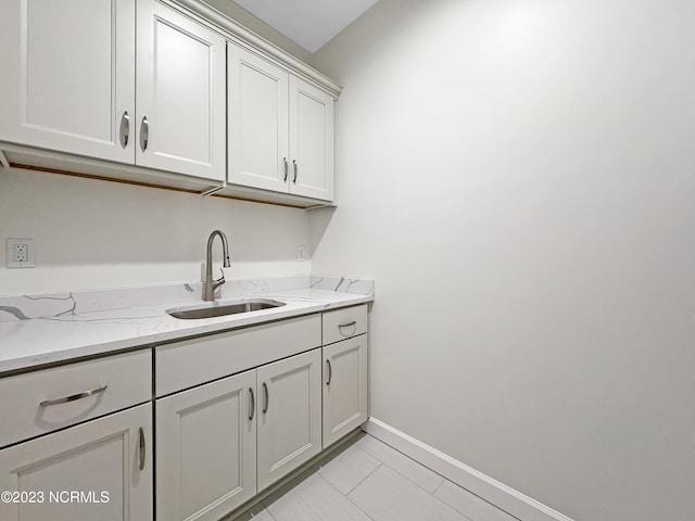 laundry area with sink and light tile flooring