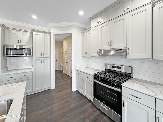 kitchen featuring light stone countertops, backsplash, dark hardwood / wood-style flooring, and stainless steel appliances