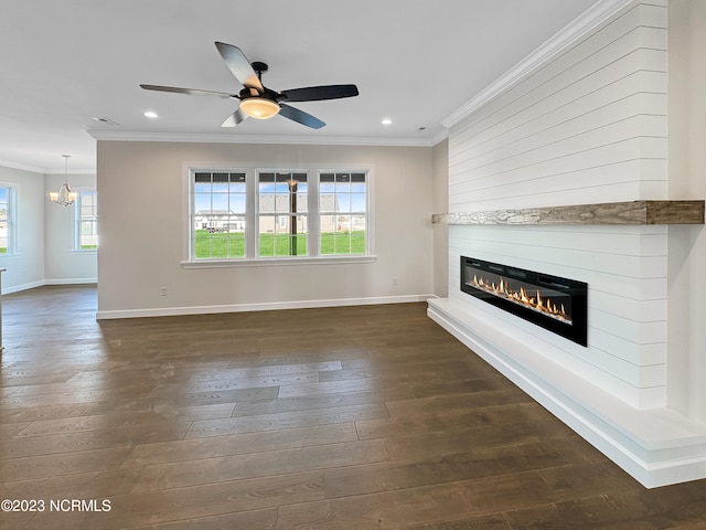 unfurnished living room with plenty of natural light, dark wood-type flooring, and ceiling fan with notable chandelier