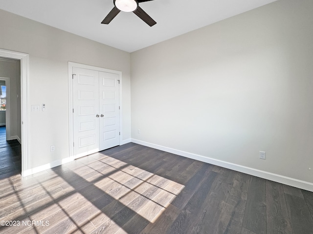 unfurnished bedroom with ceiling fan, a closet, and dark hardwood / wood-style floors