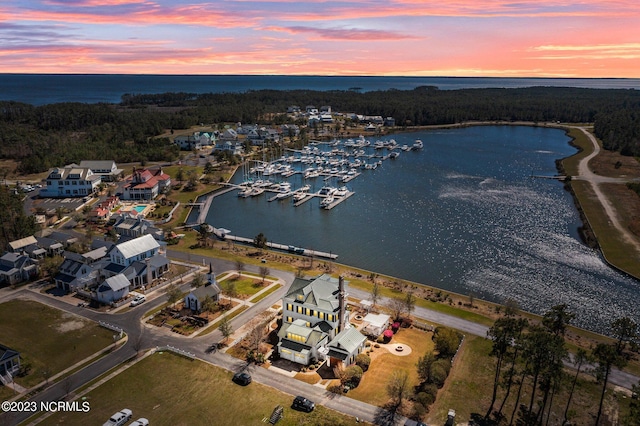 aerial view at dusk featuring a water view