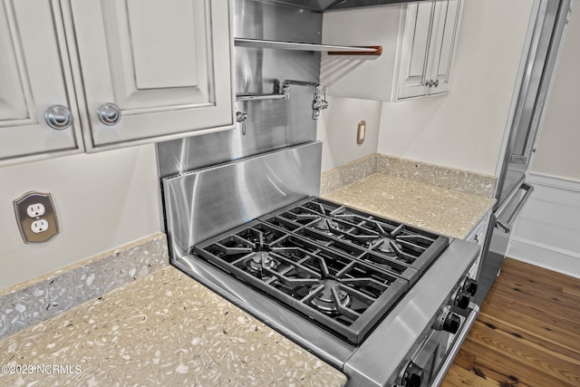 kitchen featuring white cabinets, dark hardwood / wood-style floors, and light stone countertops