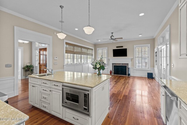 kitchen with white cabinets, pendant lighting, dark wood-type flooring, and stainless steel appliances