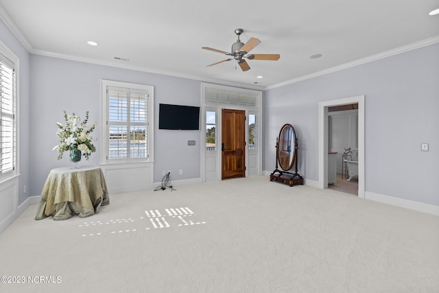 interior space featuring light colored carpet, ornamental molding, and ceiling fan