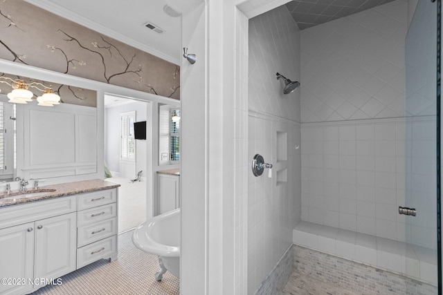 bathroom featuring a tile shower, ornamental molding, vanity, and tile flooring