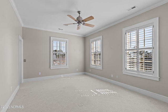 carpeted empty room with ceiling fan, ornamental molding, and plenty of natural light