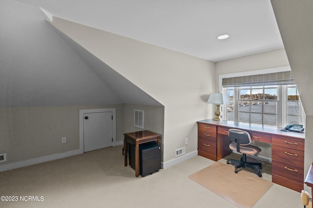 office area with light carpet, vaulted ceiling, and a water view